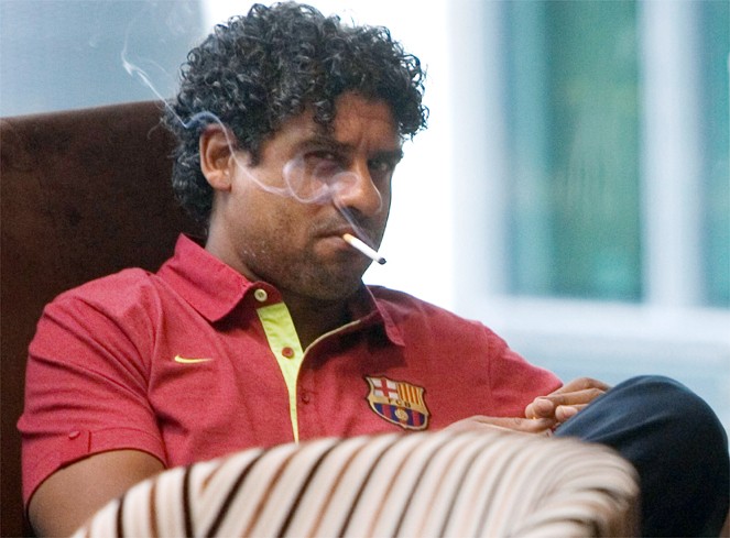 Cựu HLV của Barcelona, Frank Rijkaard phì phèo thở khói thuốc.